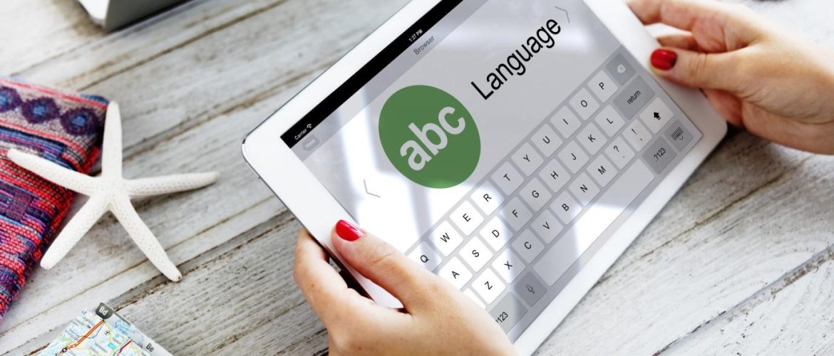 يدان تحملان جهازًا لوحيًا مفتوحًا على تطبيق ترجمة لغات.